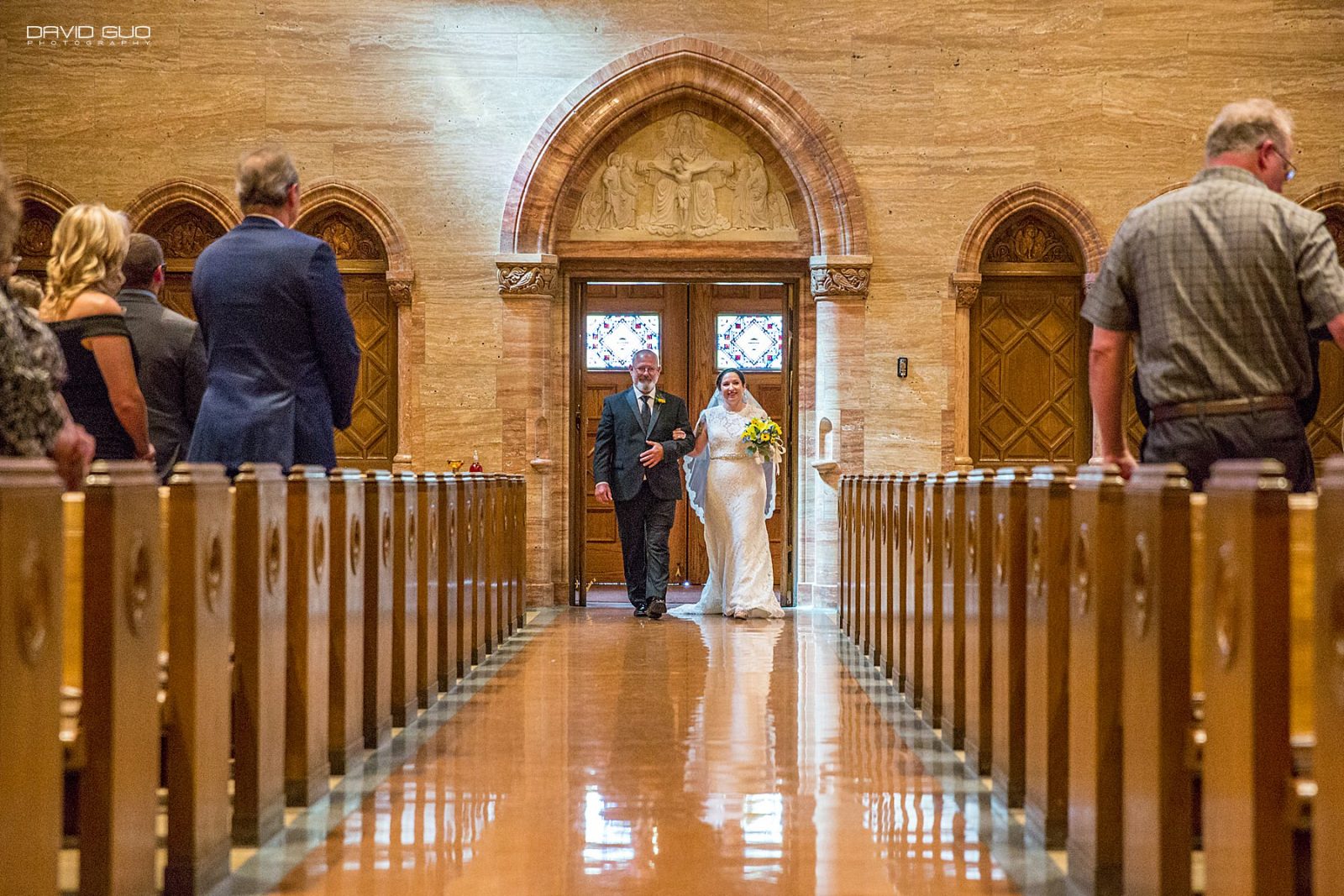 bride walks down the aisle at Holy Ghost Church in Denver